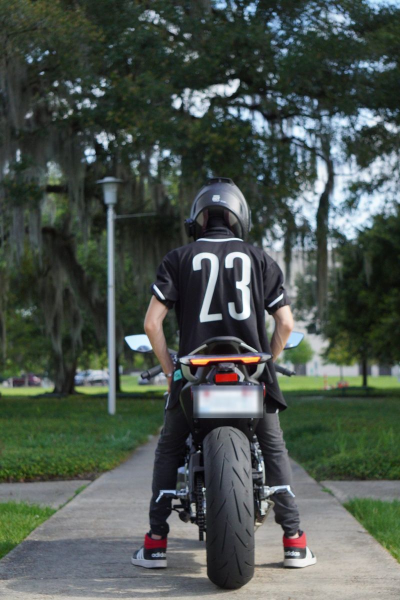 Rider seen from behind on the motorcycle, wearing a number 23 jersey